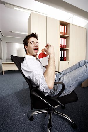 Office worker eating Chinese food at desk Stock Photo - Premium Royalty-Free, Code: 644-01825279