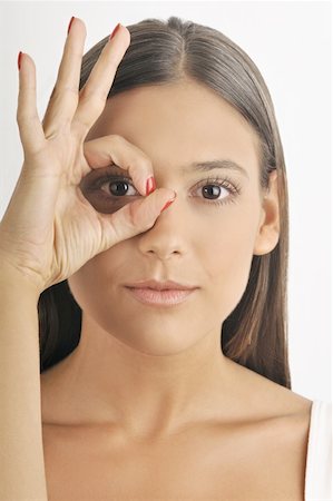 simsearch:644-02152735,k - Female young adult;looking through fingers' hole Stock Photo - Premium Royalty-Free, Code: 644-02152713