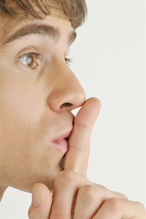 Jeune adulte mâle, le doigt sur les lèvres Photographie de stock - Premium Libres de Droits, Code: 644-02152841