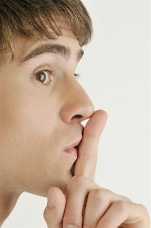 Jeune adulte mâle, le doigt sur les lèvres Photographie de stock - Premium Libres de Droits, Code: 644-02152842