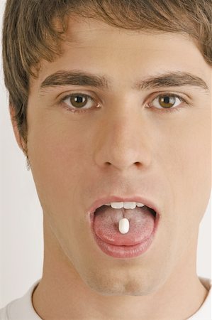 simsearch:644-02153053,k - Young male adult with pill on tongue Foto de stock - Sin royalties Premium, Código: 644-02152869