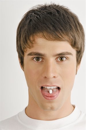 simsearch:644-02153053,k - Young male adult with pill on tongue Foto de stock - Sin royalties Premium, Código: 644-02152871