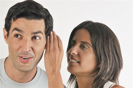 Female young adult whispering in man's ear Stock Photo - Premium Royalty-Free, Code: 644-02152886