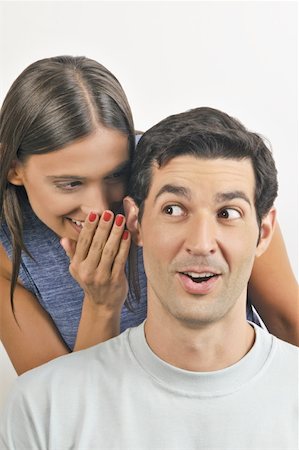Female young adult whispering in man's ear Stock Photo - Premium Royalty-Free, Code: 644-02152897
