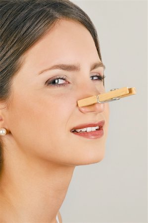 smelly - Female young adult with clothes pin on nose Stock Photo - Premium Royalty-Free, Code: 644-02152953