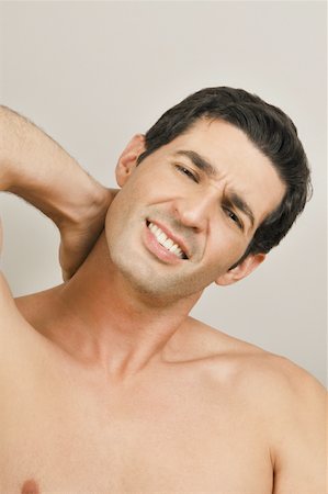 Young male adult;holding neck in pain Stock Photo - Premium Royalty-Free, Code: 644-02153034