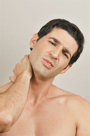 Young male adult;holding neck in pain Stock Photo - Premium Royalty-Free, Code: 644-02153033