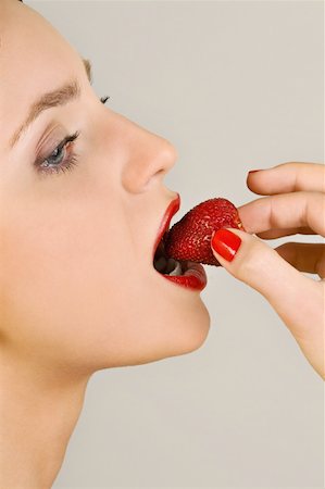simsearch:644-02153088,k - Female young adult eating a strawberry Stock Photo - Premium Royalty-Free, Code: 644-02153069