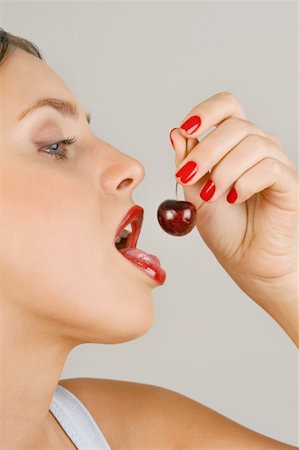 simsearch:644-02153088,k - Female young adult eating a cherry Stock Photo - Premium Royalty-Free, Code: 644-02153085