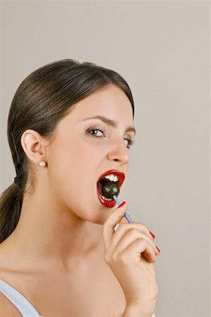 picture of a red lollipop - Female young adult biting a lollipop Stock Photo - Premium Royalty-Free, Code: 644-02153080