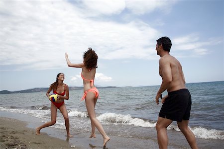 Deux jeunes adultes femelles et un mâle, jouer au ballon sur la plage Photographie de stock - Premium Libres de Droits, Code: 644-02153264