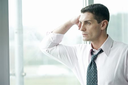 depression work - Businessman looking out the window Stock Photo - Premium Royalty-Free, Code: 644-02923271