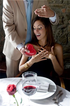 fine dining restaurant - Young man surprising young woman with a present Stock Photo - Premium Royalty-Free, Code: 644-03405299