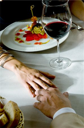 fine dining restaurant - Closeup of couple's hands touching at dinner table Stock Photo - Premium Royalty-Free, Code: 644-03405329
