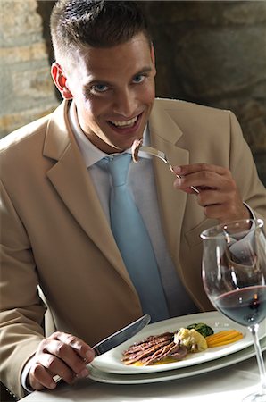 fine dining restaurant - Young man eating with glass of wine at a restaurant Stock Photo - Premium Royalty-Free, Code: 644-03405342
