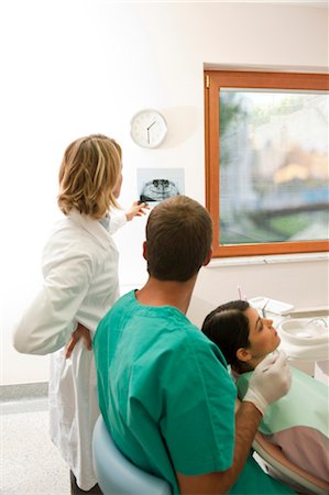 Patient with dental professionals looking at dental panoramic xray Stock Photo - Premium Royalty-Free, Code: 644-03659553