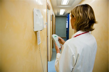 Doctor making telephone call in medical center Stock Photo - Premium Royalty-Free, Code: 644-03659565