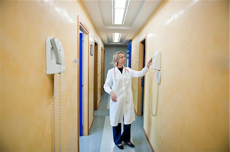 Doctor making telephone call in medical center Stock Photo - Premium Royalty-Free, Code: 644-03659566