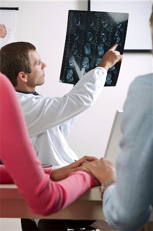 skeletal women in medicine - Doctor showing MRI to patient Stock Photo - Premium Royalty-Free, Code: 644-03659672