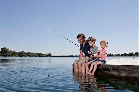 Père et enfants sur le quai de pêche Photographie de stock - Premium Libres de Droits, Code: 649-04247698