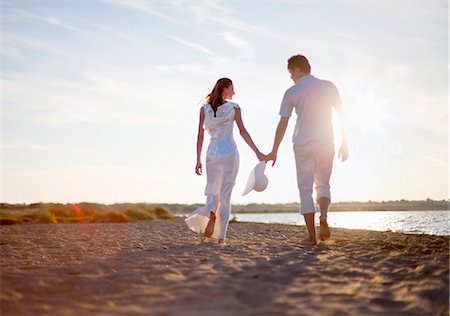 romantic couple holding hands - Newlywed couple walking on beach Foto de stock - Sin royalties Premium, Código: 649-04248579