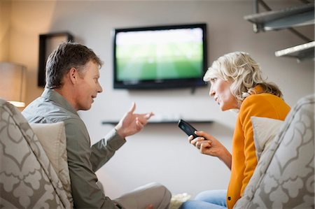 Couple arguing over remote control Stock Photo - Premium Royalty-Free, Code: 649-04827380