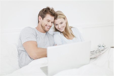 simsearch:649-06717020,k - Smiling couple using laptop in bed Stock Photo - Premium Royalty-Free, Code: 649-04827565