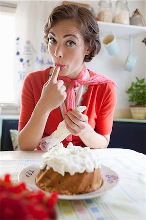 retro cooking - Woman icing a cake in kitchen Stock Photo - Premium Royalty-Free, Code: 649-05520883