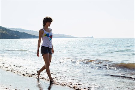 pictures of woman running with short hair - Woman walking in waves on beach Stock Photo - Premium Royalty-Free, Code: 649-05521443