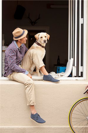 dog bicycle - Man sitting with dog in windowsill Stock Photo - Premium Royalty-Free, Code: 649-05522150