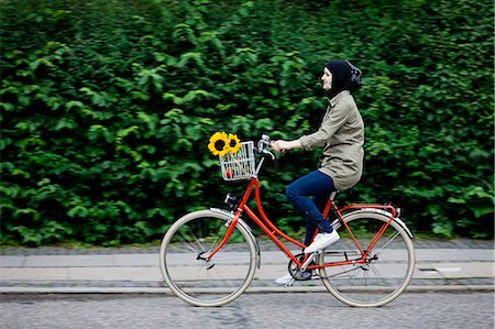 riding bike female basket - Woman in headscarf biking on cell phone Stock Photo - Premium Royalty-Free, Code: 649-05522607