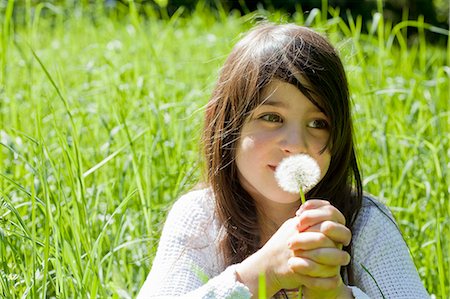 Girl smelling dandelion in tall grass Stock Photo - Premium Royalty-Free, Code: 649-05555586