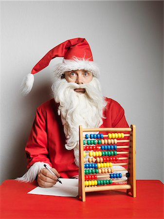 retro christmas person - Man in Santa Claus suit using abacus Stock Photo - Premium Royalty-Free, Code: 649-05555663