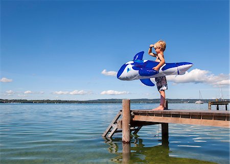 Boy holding inflatable whale on dock Foto de stock - Sin royalties Premium, Código: 649-05556074