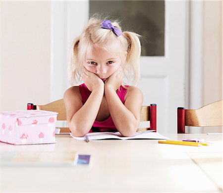 pigtails - Bored girl doing homework at table Stock Photo - Premium Royalty-Free, Code: 649-05556124