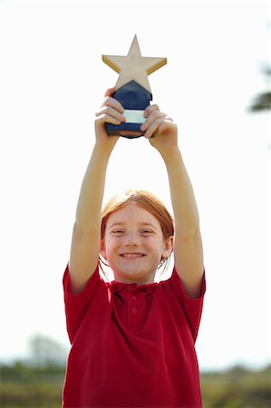 red hair preteen girl - Girl cheering with trophy outdoors Foto de stock - Sin royalties Premium, Código: 649-05556204