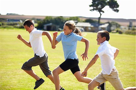 running in field - Smiling children racing in field Stock Photo - Premium Royalty-Free, Code: 649-05556207