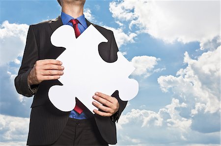 Businessman holding puzzle piece Stock Photo - Premium Royalty-Free, Code: 649-05657047