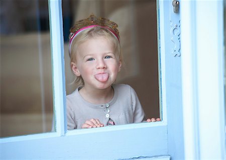 Toddler girl in tiara making a face Stock Photo - Premium Royalty-Free, Code: 649-05657079