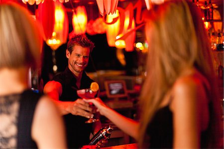 Bartender handing woman a cocktail Foto de stock - Sin royalties Premium, Código: 649-05657337