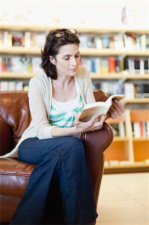 Woman reading book in library Stock Photo - Premium Royalty-Free, Code: 649-05657435