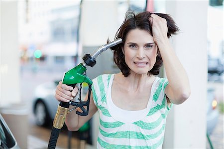 Frustrated woman pumping gas into hair Stock Photo - Premium Royalty-Free, Code: 649-05657448
