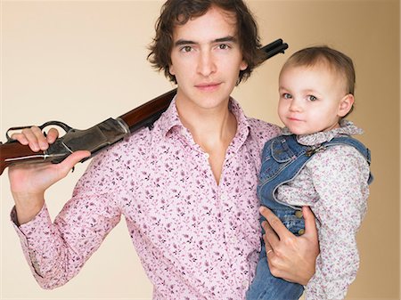 Father holding toddler and shotgun Stock Photo - Premium Royalty-Free, Code: 649-05657917