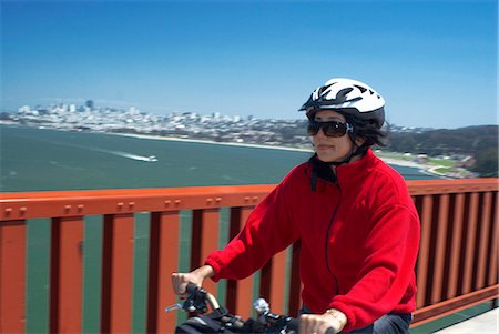 Woman riding bike on urban bridge Stock Photo - Premium Royalty-Free, Code: 649-05658132