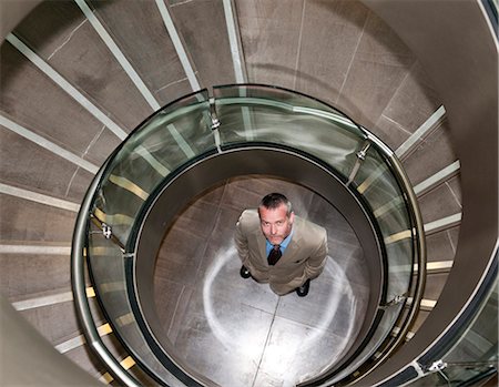 steps high angle - Businessman standing in spiral staircase Stock Photo - Premium Royalty-Free, Code: 649-05658249