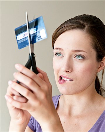 Woman cutting up credit card Stock Photo - Premium Royalty-Free, Code: 649-05658253