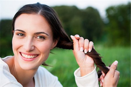 simsearch:649-05819818,k - Smiling woman playing with her hair Stock Photo - Premium Royalty-Free, Code: 649-05800972