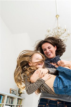 parents tickling children - Woman playing with daughter in kitchen Stock Photo - Premium Royalty-Free, Code: 649-05800984