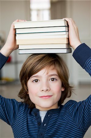 schoolboy - Boy balancing books on his head Stock Photo - Premium Royalty-Free, Code: 649-05801001