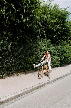 Woman riding bicycle on rural road Stock Photo - Premium Royalty-Free, Code: 649-05801156
